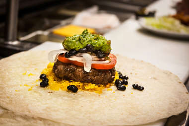 Next comes a scoop of guacamole on the Supreme Nacho Burger at Slater's 50/50 in Liberty Station San Diego.