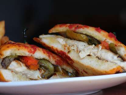 A sandwich with grilled peppers and cheesy bread.