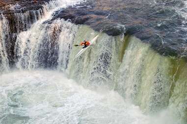 dane paddles over a waterfall