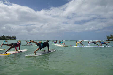 people doing yoga on surfboards