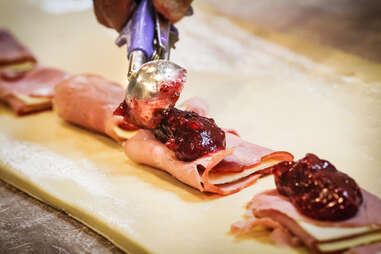 Spreading the cran raspberry sauce on the ham and cheese to make the monte cristo sandwiches at Donut Bar in downtown San Diego.